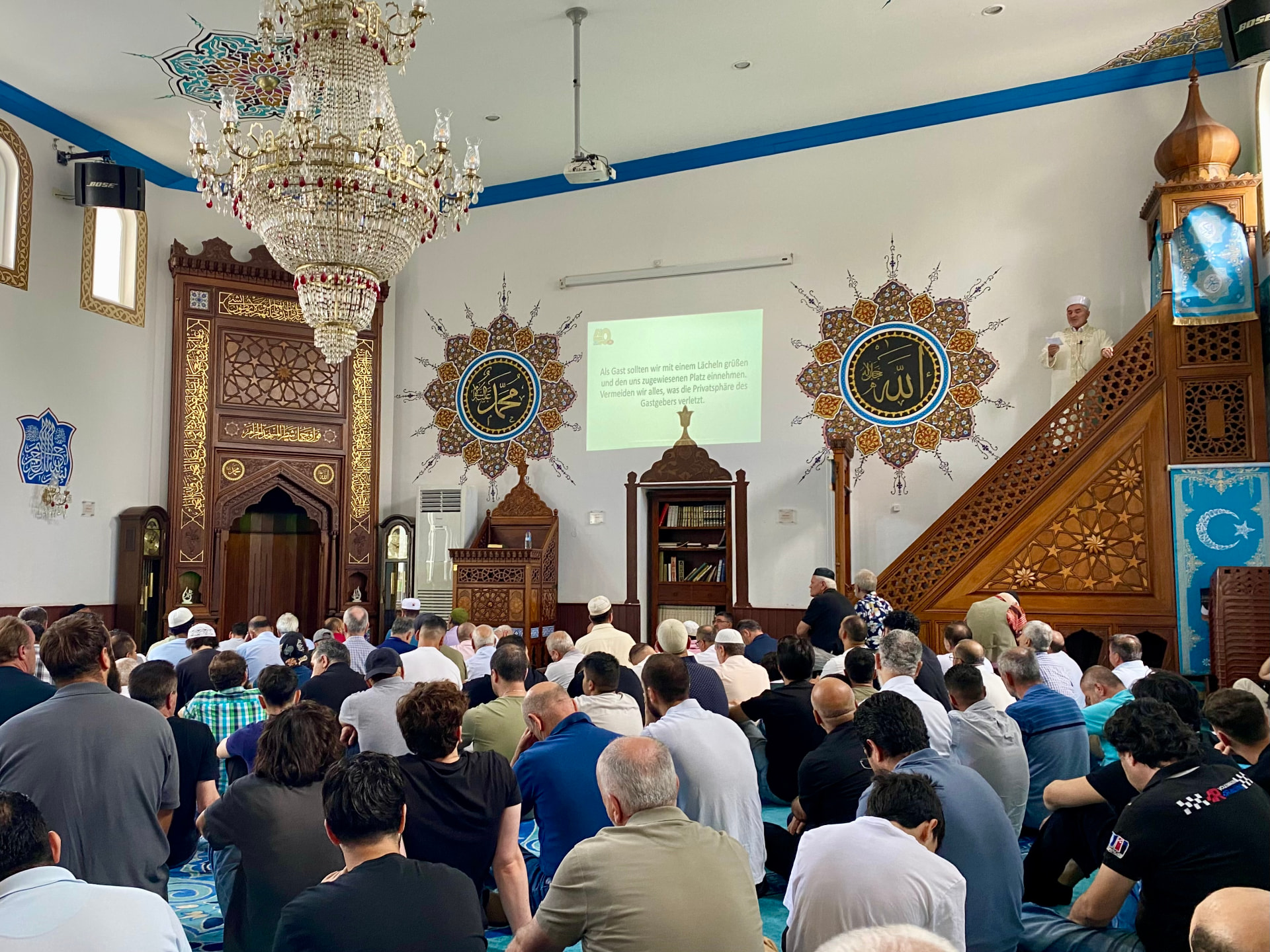 Gemeinde beim Freitagsgebet in der Yavuz Sultan Selim Moschee, im Hintergrund der Imam auf der Minbar während der Hutba